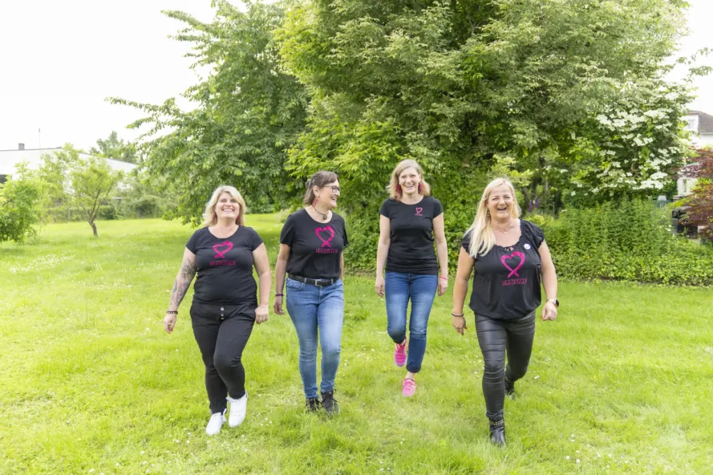 Die vier Herzkissen-Gründerinnen laufen lachend über eine grüße Wiese